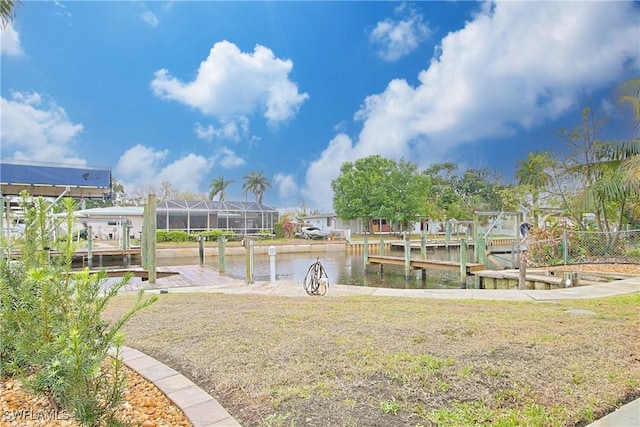 view of property's community with a boat dock, a water view, a residential view, and a yard