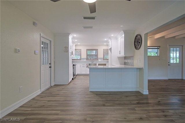 kitchen featuring a peninsula, visible vents, white cabinets, and dark wood finished floors