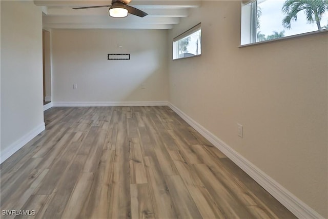 spare room featuring a ceiling fan, baseboards, beam ceiling, and wood finished floors