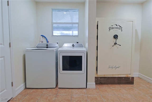 washroom featuring light tile patterned floors, washing machine and clothes dryer, and baseboards