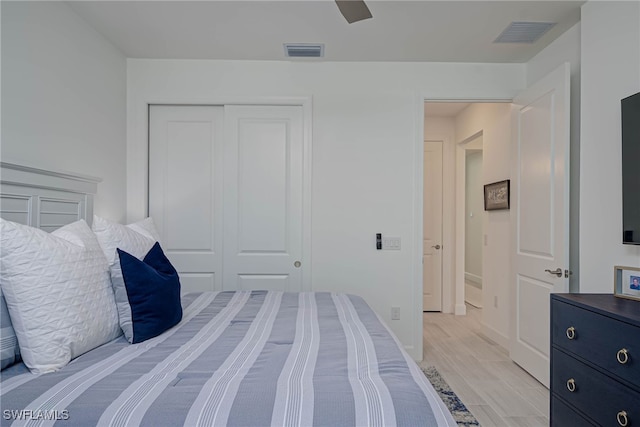 bedroom with a ceiling fan, a closet, visible vents, and light wood-style flooring