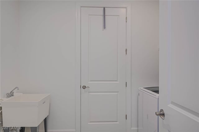 laundry area with laundry area, a sink, and washer / dryer
