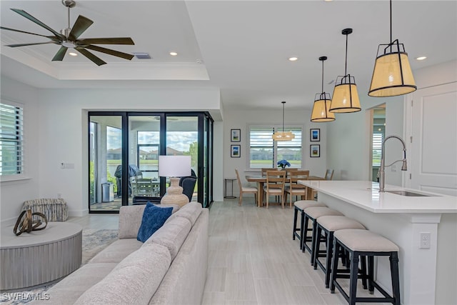 living room featuring crown molding, a tray ceiling, and recessed lighting