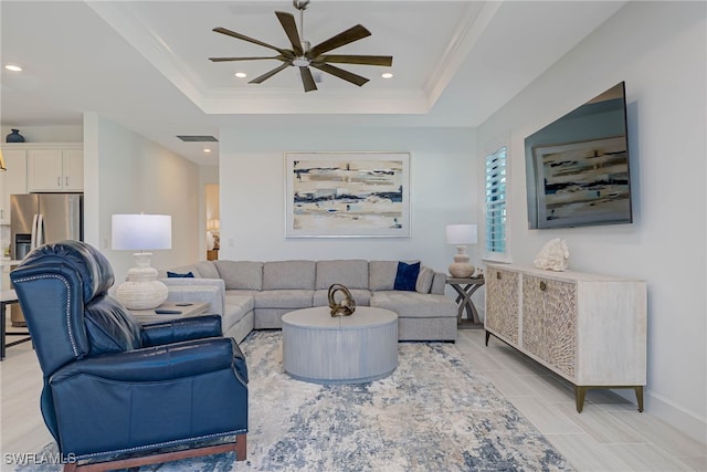 living room with ornamental molding, a raised ceiling, and recessed lighting