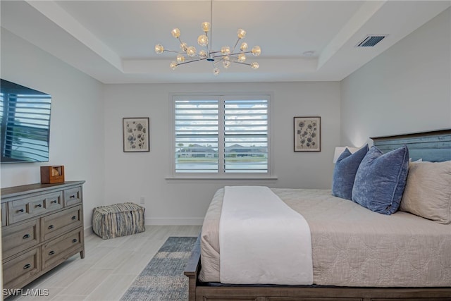 bedroom featuring a chandelier, a tray ceiling, visible vents, and baseboards