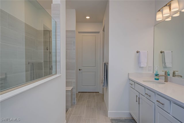 bathroom with recessed lighting, vanity, baseboards, and a walk in shower