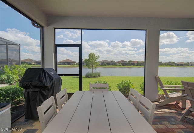 sunroom / solarium featuring a water view