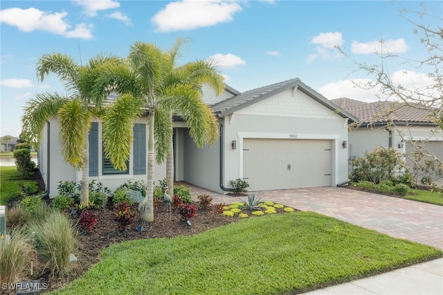 single story home with a front yard, decorative driveway, an attached garage, and stucco siding
