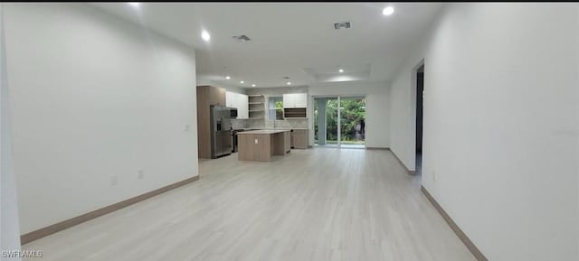 living room with recessed lighting, visible vents, light wood finished floors, and baseboards