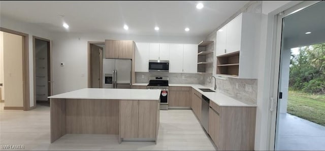 kitchen with open shelves, appliances with stainless steel finishes, backsplash, and a sink