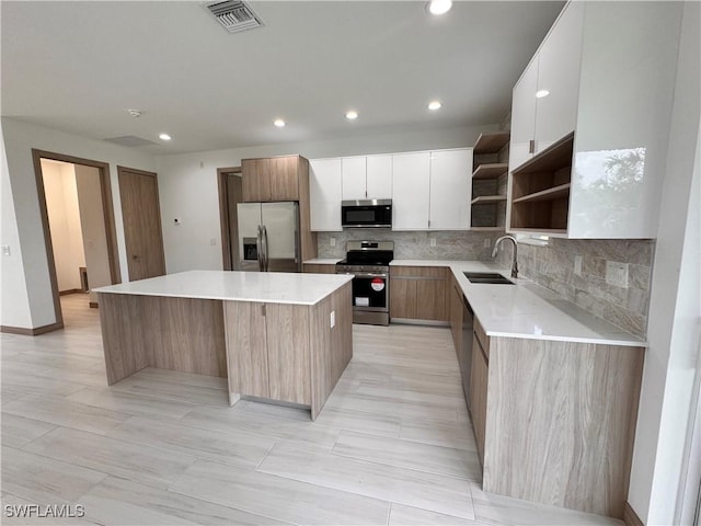 kitchen featuring appliances with stainless steel finishes, visible vents, a sink, and modern cabinets