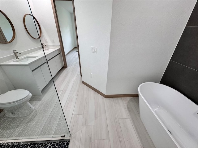 full bath featuring double vanity, a freestanding tub, baseboards, and a sink