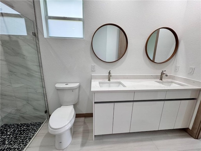 bathroom featuring a sink, a shower stall, toilet, and double vanity