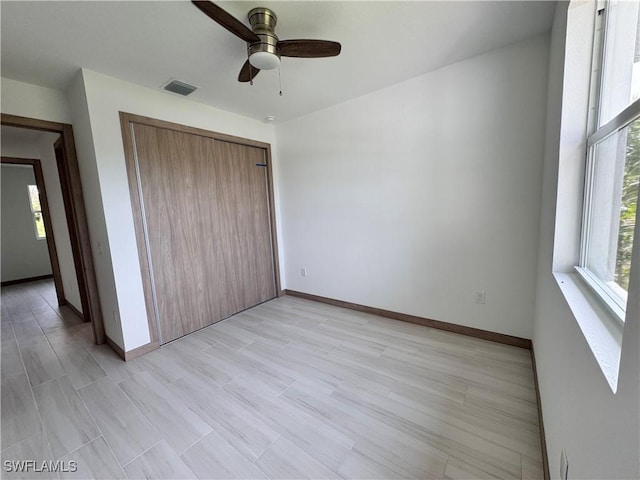 unfurnished bedroom with a closet, visible vents, light wood finished floors, and baseboards