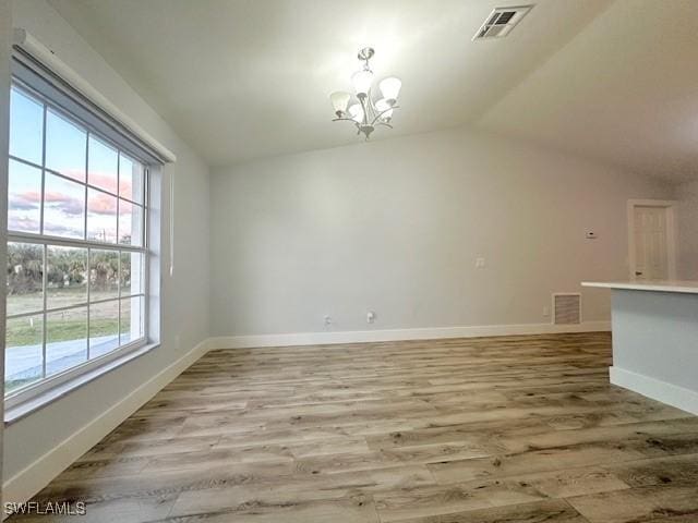 interior space with a notable chandelier, vaulted ceiling, and visible vents