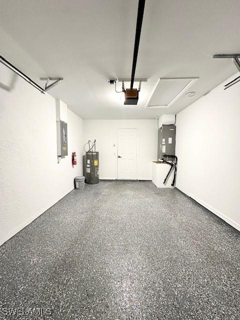 garage featuring water heater, a garage door opener, electric panel, and heating unit