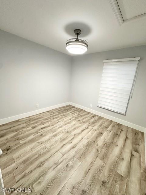 spare room with light wood-style flooring and baseboards