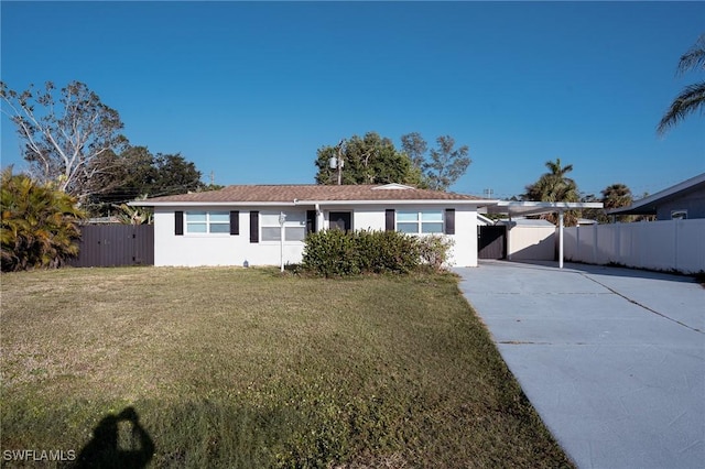 single story home featuring driveway, fence, a front lawn, a carport, and stucco siding