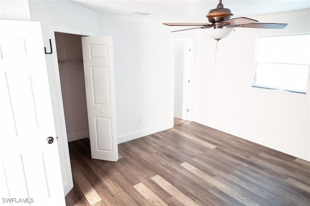 unfurnished bedroom with wood finished floors, a ceiling fan, visible vents, baseboards, and a closet