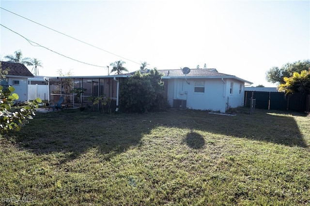 view of yard with a sunroom, a fenced backyard, and cooling unit