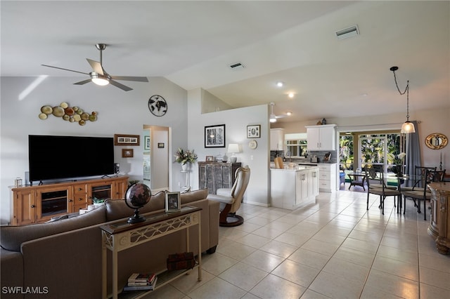 living area with lofted ceiling, visible vents, ceiling fan, and light tile patterned floors