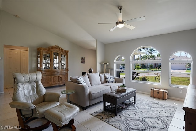 living area featuring light tile patterned floors, vaulted ceiling, baseboards, and ceiling fan