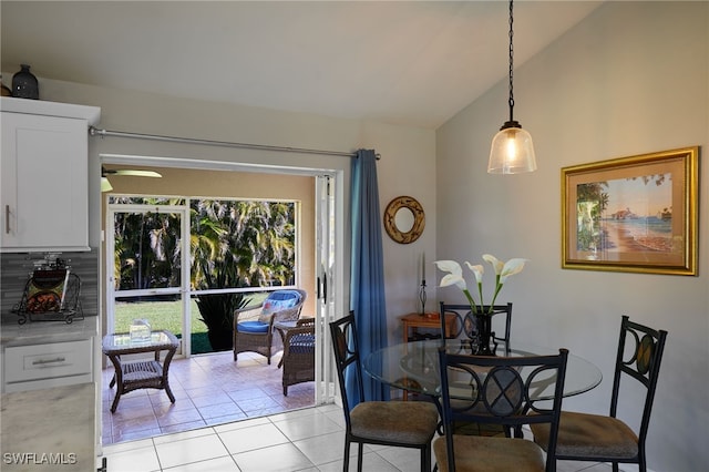 dining room with light tile patterned floors and vaulted ceiling