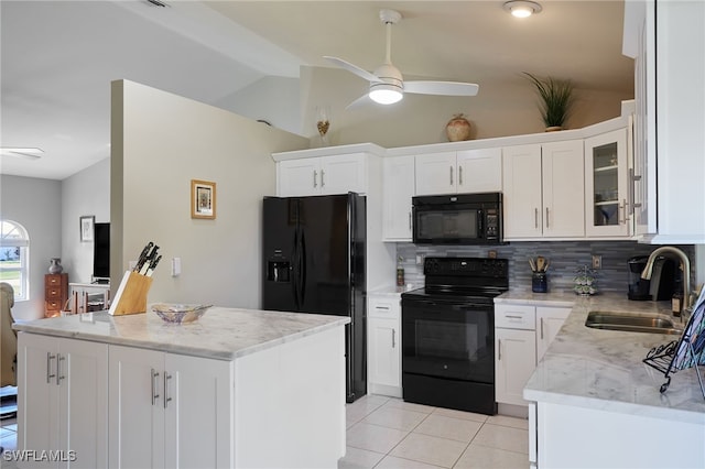 kitchen with light tile patterned floors, lofted ceiling, backsplash, a sink, and black appliances