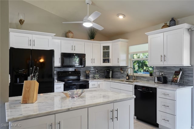 kitchen featuring decorative backsplash, lofted ceiling, black appliances, white cabinetry, and a sink