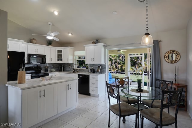 kitchen with light tile patterned floors, white cabinets, a sink, black appliances, and backsplash