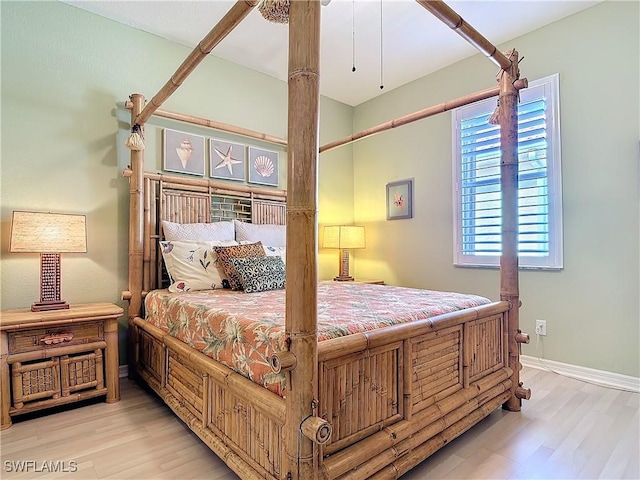 bedroom with light wood-style flooring and baseboards