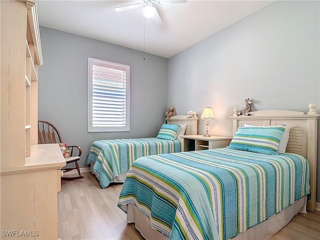 bedroom with light wood finished floors, a ceiling fan, and baseboards