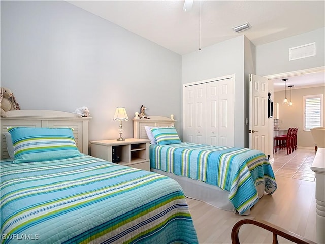 bedroom with a closet, wood finished floors, and visible vents