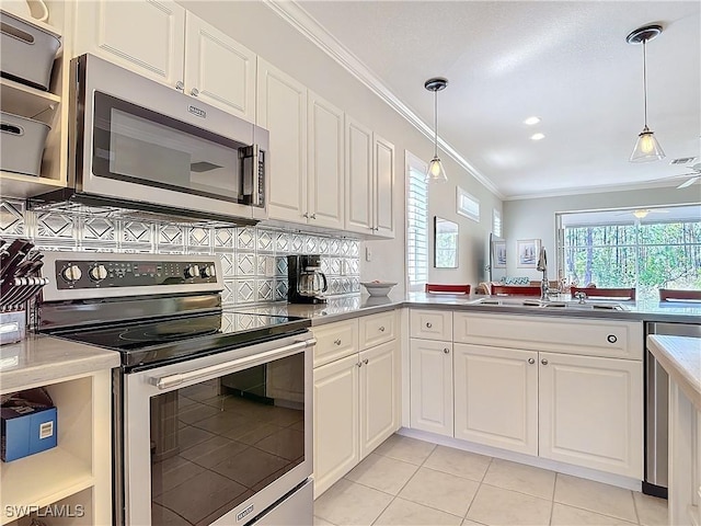 kitchen featuring decorative light fixtures, crown molding, stainless steel appliances, decorative backsplash, and a sink