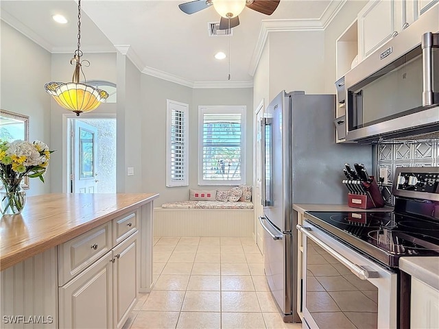 kitchen featuring plenty of natural light, visible vents, appliances with stainless steel finishes, and ornamental molding