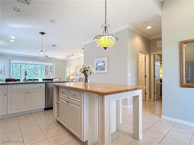 kitchen with refrigerator, butcher block counters, a sink, visible vents, and ornamental molding