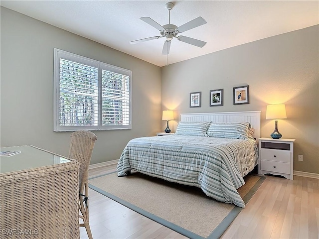 bedroom with a ceiling fan, light wood-type flooring, and baseboards