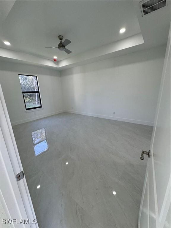 unfurnished room featuring recessed lighting, a raised ceiling, visible vents, ceiling fan, and baseboards