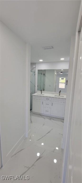 1025 Pilgrim St E, Lehigh Acres, FL 33974 - bathroom featuring double vanity, marble look tiles, a marble finish shower, baseboards, and recessed lighting