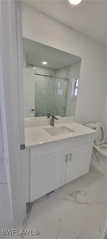 full bath with toilet, marble finish floor, a marble finish shower, and vanity