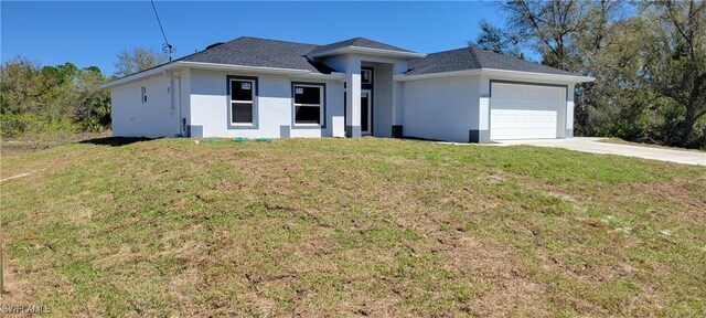 view of front of home featuring a front yard, an attached garage, and stucco siding