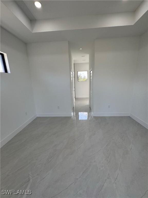 spare room featuring recessed lighting and baseboards