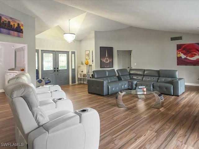 living room featuring visible vents, baseboards, lofted ceiling, french doors, and wood finished floors