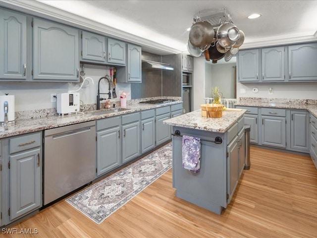 kitchen with a kitchen island, light wood-style flooring, gray cabinetry, a sink, and appliances with stainless steel finishes