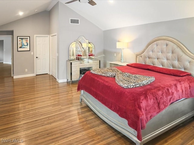 bedroom featuring vaulted ceiling, wood finished floors, visible vents, and baseboards