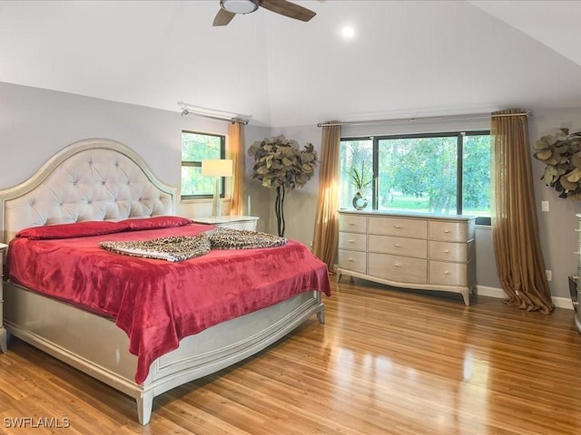 bedroom with multiple windows, wood finished floors, and high vaulted ceiling