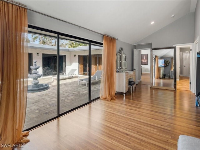 interior space featuring high vaulted ceiling and wood finished floors