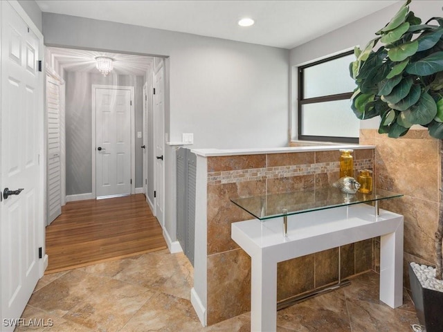 hallway featuring recessed lighting and tile walls