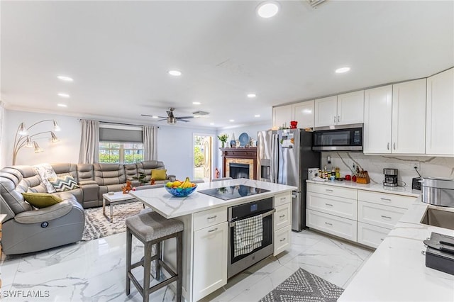 kitchen featuring recessed lighting, white cabinetry, open floor plan, appliances with stainless steel finishes, and decorative backsplash