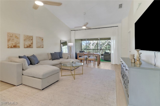 living room featuring visible vents, high vaulted ceiling, light wood-type flooring, and a ceiling fan